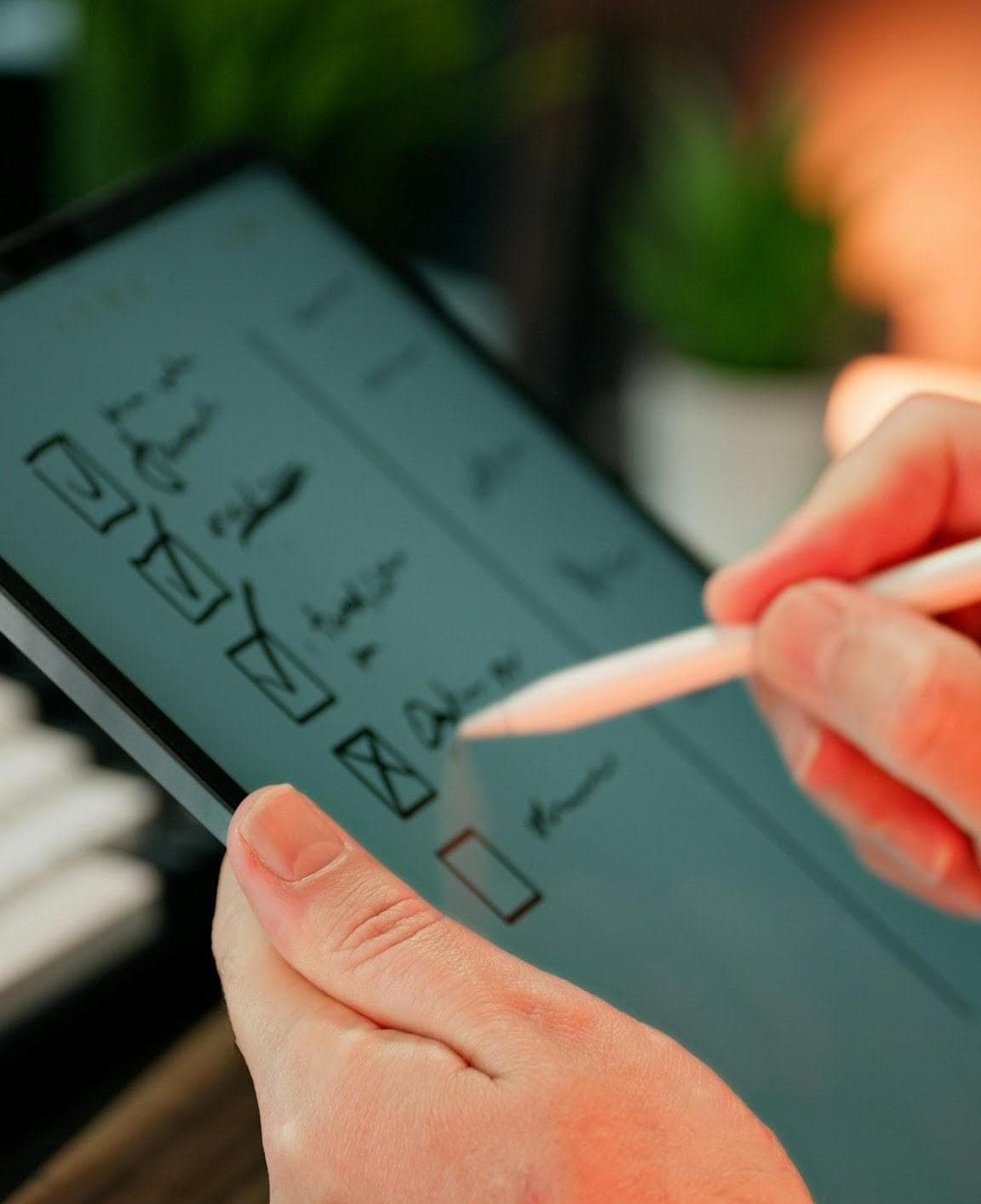 Une main qui coche des tâches sur une tablette